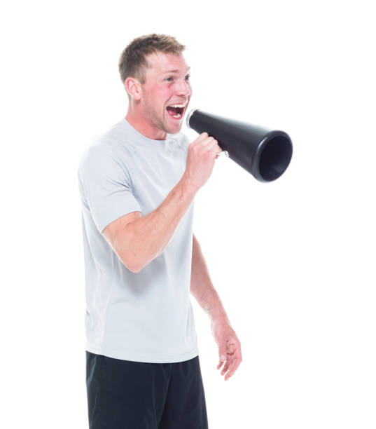 istock Attracitve man in sports clothing using a small megaphone 1174007244