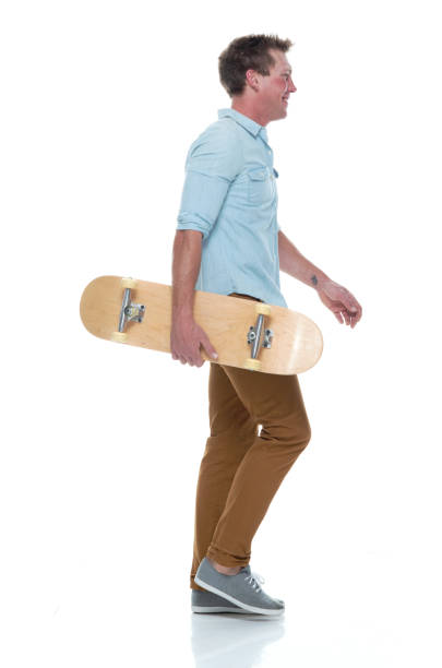 istock Casual well dressed man walking with a skateboard 1174009292