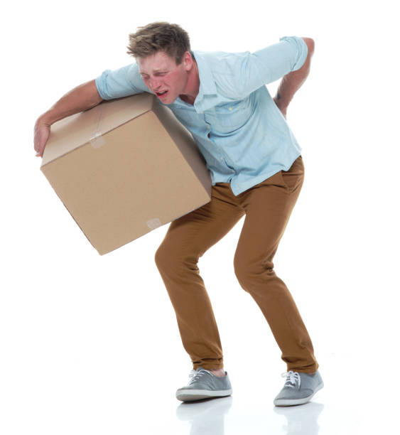 istock Good looking man holding a brown box and has back pain 1174009388