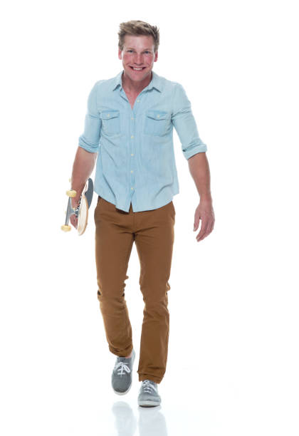 istock Casual well dressed man walking with a skateboard 1174009418