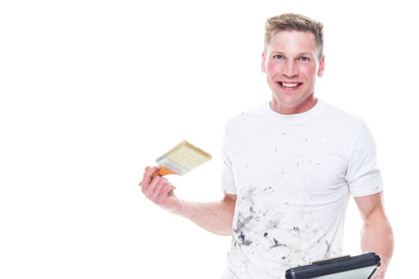 istock Very good looking young white painter on white background - holding clipboard 1174012242