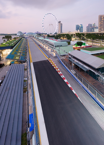 Singapore - 9 Sep 2019: the Marina Bay Street circuit is getting ready to welcome the Singapore night race Formula One Grand Prix. The grandstand is looking over the Flyer Ferris wheel, the Gardens by the bay and the Sands resorts.