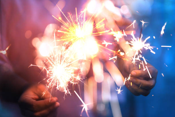 istock Hand of woman holding firework pyrotechnics and bokeh with blurry effect on the dark background for celebration concept 1174018919