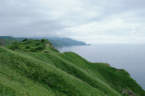 Seascape on mountain cliff view, the green hills on top view,windy with sea coastline and shore scenery,tourism trail at Cape of Kamui Island in Shakotan,Hokkaido,Japan