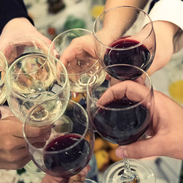 istock People clinking glasses above reataurant dinner table at some festive occasion. Drinking toasts and clinking tumblers at a dinner party. Drinking wine at a banquet. Men and women feast an event 1174023429