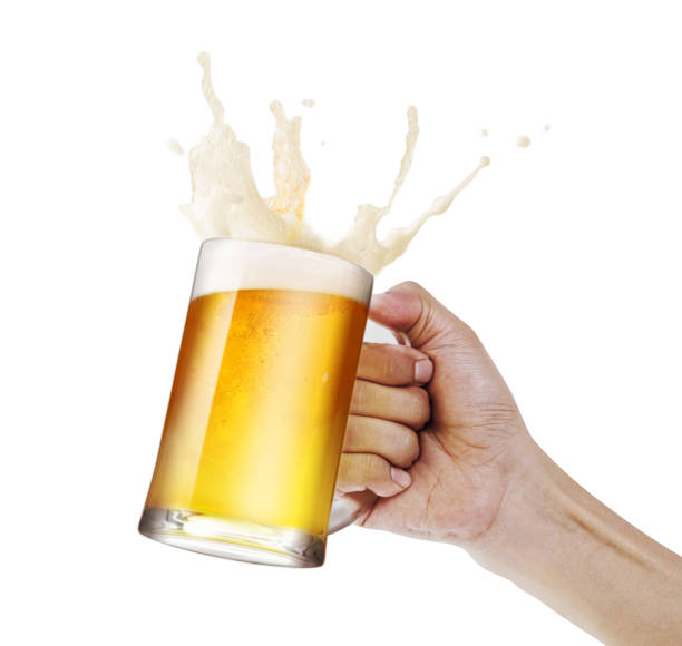 Hand holding a mug of light beer toasting with bubble froth splash isolate white background with copy space