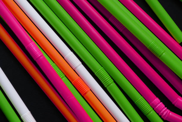 istock Plastic straws different colors on a dark background close up 1174037939
