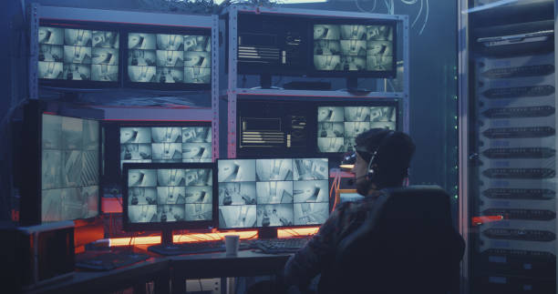 Medium shot of a hacker watching hacked security camera footage