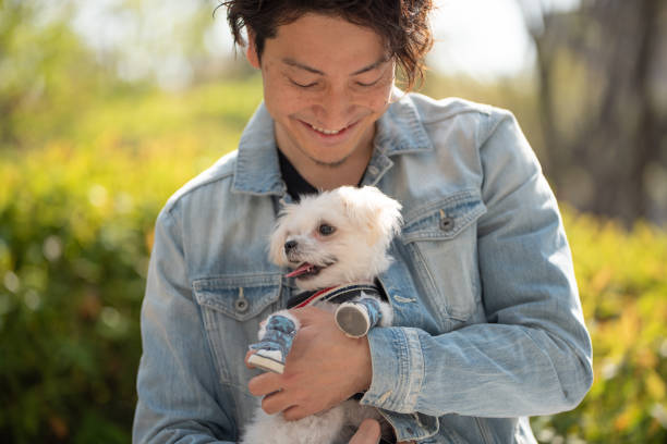 istock Man embracing puppy on street 1174042675