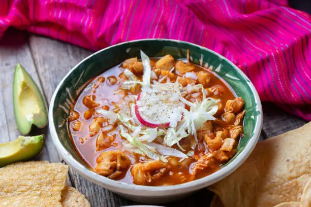 Traditional mexican red pozole soup on wooden background