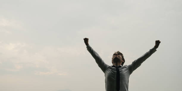 istock Businessman standing under sky with his arms raised 1174051906