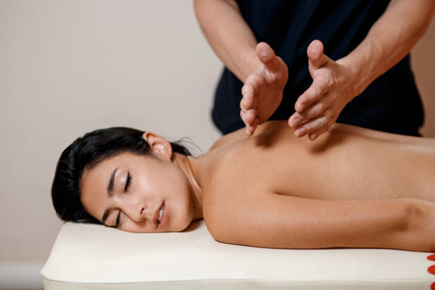 istock A young woman gets a massage procedure. Masseur makes back massage 1174052325