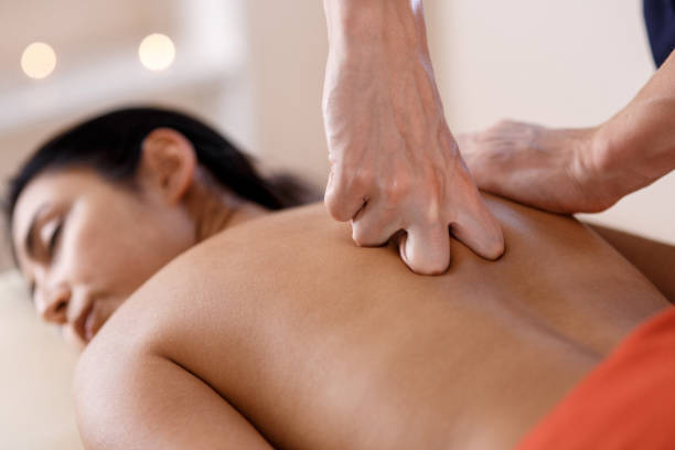 istock A young woman gets a massage procedure. Masseur makes back massage 1174052528
