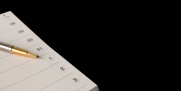istock The calendar in the notebook on black background 1174052649
