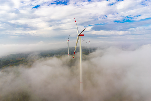 Wind turbine in the fog in the forest aerial view and close-up view