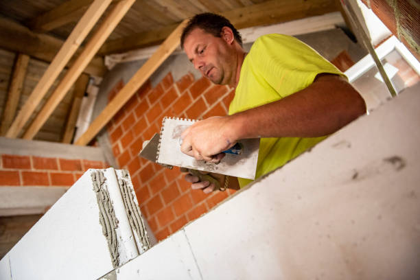 istock Real construction worker making a wall inside the new house 1174054339
