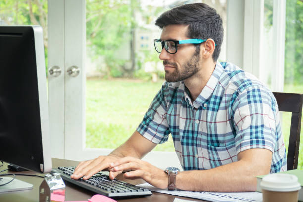 istock Good looking young business man working on the internet at home 1174056630
