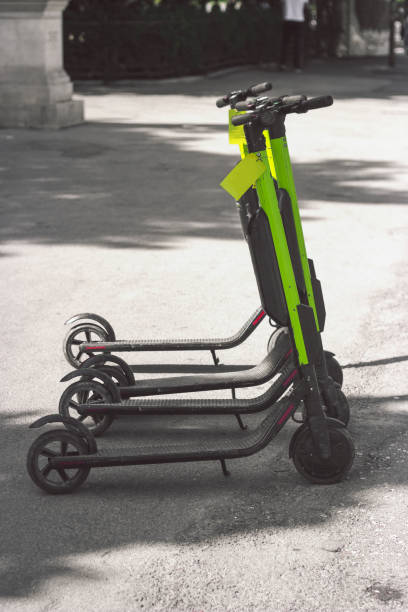 Electic scooters parked on the street, with copy space Electic scooters parked on the street, with copy space lime scooter stock pictures, royalty-free photos & images