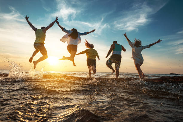 amigos felices corre al lago al atardecer después de la fiesta - teenager team carefree relaxation fotografías e imágenes de stock