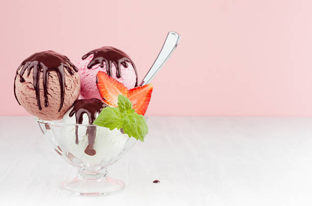 o gelado da baunilha colheres o sabor diferente com molho de chocolate, hortelã, morango, colher na bacia elegante no interior cor-de-rosa pastel à moda moderno. - ice cream vanilla ice cream bowl white - fotografias e filmes do acervo