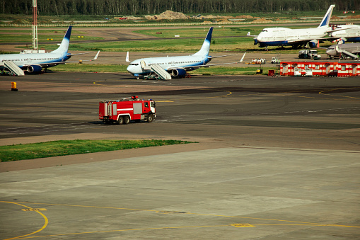 Fire truck on the runway near the aircraft. Airport Rescue Service. Firefighters and fire department at the airport. Crisis Response System