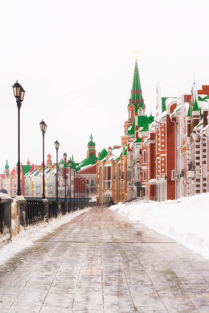 Russia, Yoshkar-Ola, Bruges embankment, March 09, 2019, cloudy winter day, view of the buildings. Parapet by the river on the left, colored brick buildings