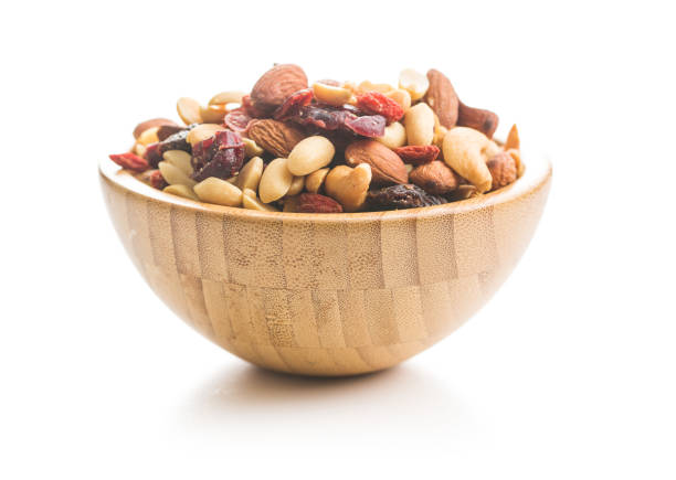 Mix of various nuts and raisins. Mix of various nuts and raisins in bowl isolated on white background. dried fruit on white stock pictures, royalty-free photos & images