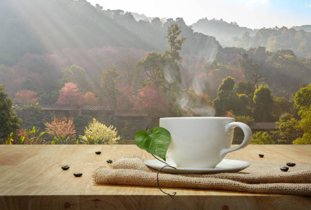 Coffee cup with burlap on the wooden table and the Sakura background