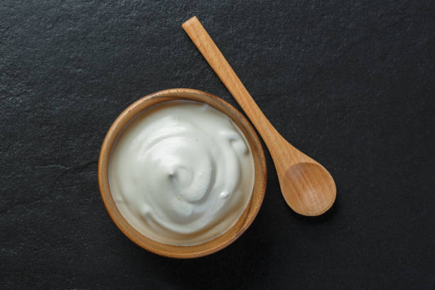 istock Greek yogurt on black stone background 1174068539