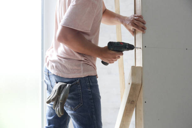 istock Process of drilling screws into plasterboard with an electric screwdriver, home improvement concept 1174069710