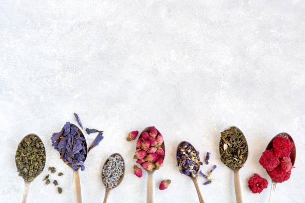 Different herbal and green dry teas in vintage spoons. Top view flat lay with copy space