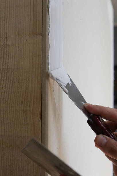 istock Man plastering wall with putty-knife. Fixing wall surface and preparation for painting. DIY housing improvement project. 1174070330