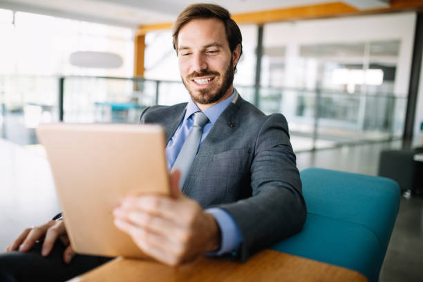 istock Young handsome business man using a digital tablet at office 1174075318