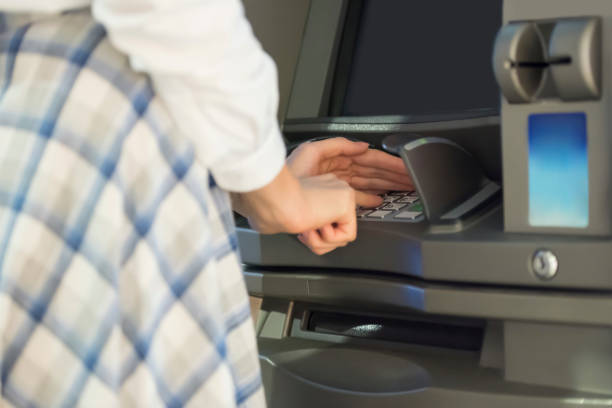 istock Woman withdrawing money from ATM 1174083805