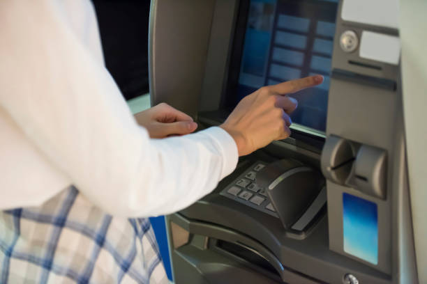 istock Woman withdrawing money from ATM 1174084417
