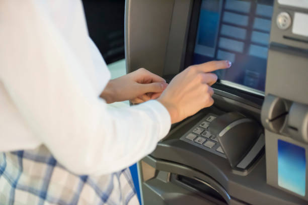 istock Woman withdrawing money from ATM 1174084639