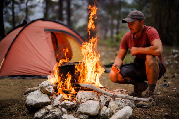 istock Man sitting near the pot on the campfire 1174084771