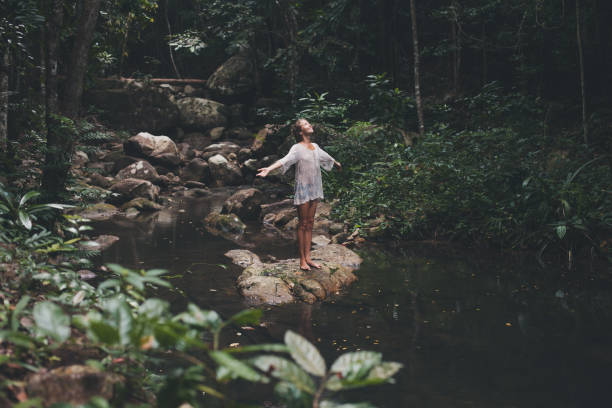 hermosa mujer joven disfruta en la naturaleza - waterfall thailand tropical rainforest tropical climate fotografías e imágenes de stock