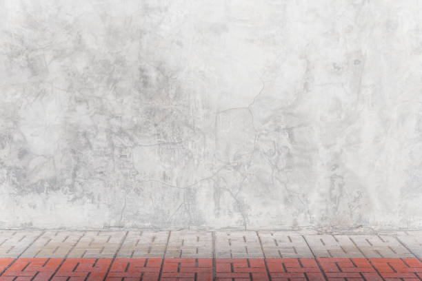 istock Empty grey concrete wall with bricks floor in room. Abstract background or backdrop. 1174093524