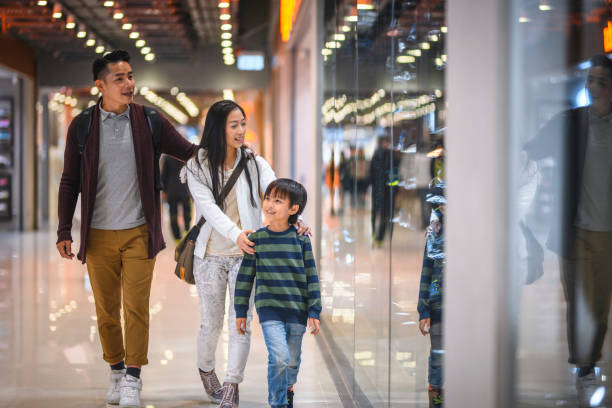 chinese couple with young son shopping at harbour city mall - harbour city imagens e fotografias de stock