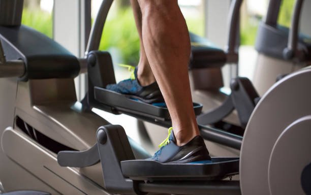 istock Man exercising on elliptical machine in gym 1174099940