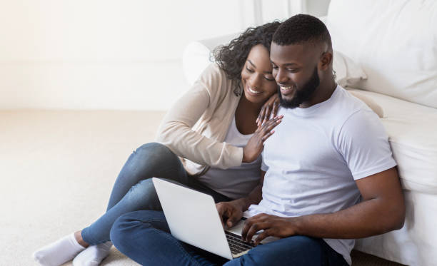 istock African couple web surfing on laptop while sitting at home 1174101384