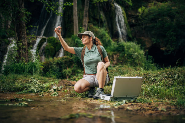 istock Woman biologist taking a water sample in nature 1174101727