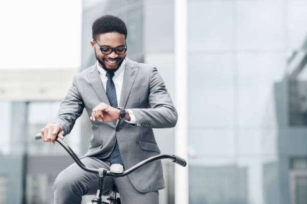 istock Handsome manager checking time on his watch, enjoying bike ride 1174103684