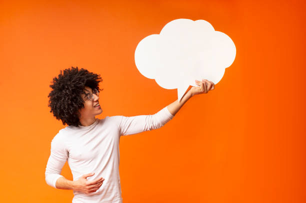 istock Cheerful black guy looking upwards at blank speech bubble 1174104194