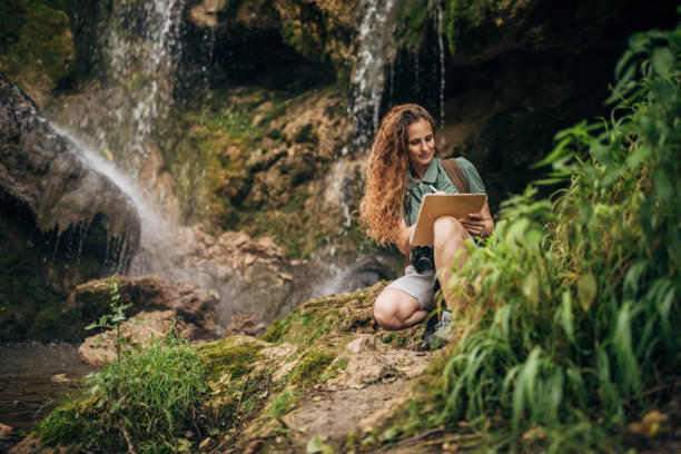 istock Woman biologist taking notes by the waterfall 1174104445