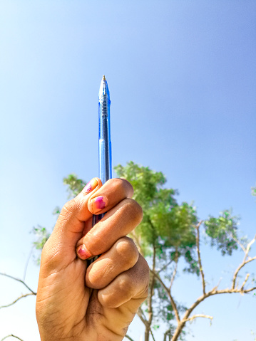 a teenage girl is rising up a pen and  towards the sky and want equal rights for education