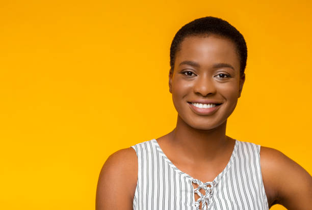 istock Attractive black girl smiling on yellow studio background 1174105927