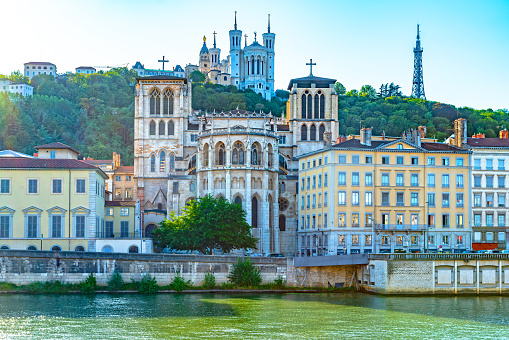 The banks of the Saone at Lyon,  with the Cathedral of Notre Dame de Fourviere in the background and the Lyon Cathedral in the foreground backlit by late afternoon sunlight.