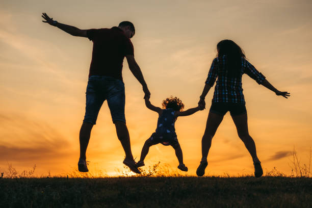 istock Family jump at sunset 1174110104